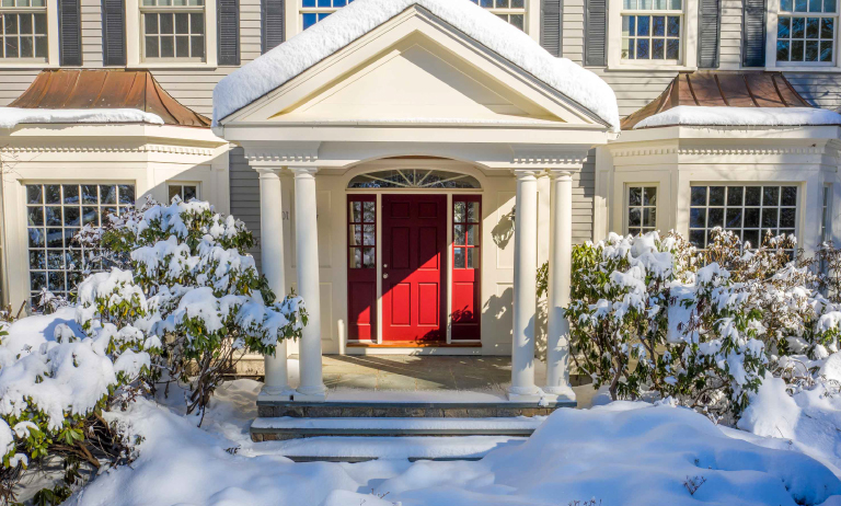 Front porch of a home with a red door